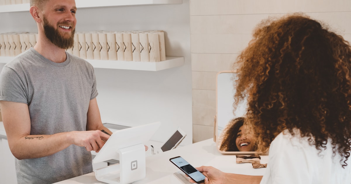 Client satisfait récupérant son appareil réparé dans un atelier